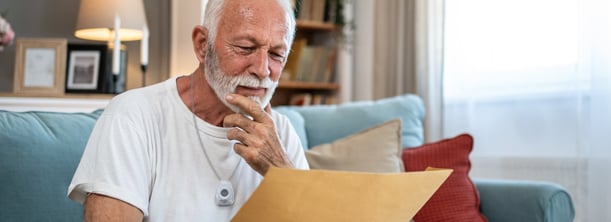 senior-man-reviewing-life-alert-cost-pricing-information-home